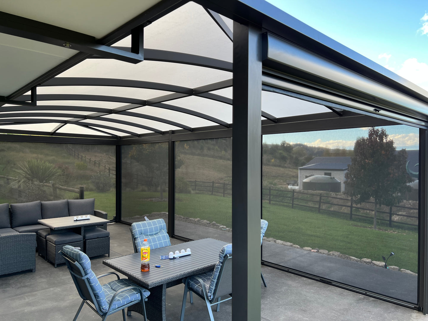 Outdoor patio area with a pergola, table, and chairs on a clear day.