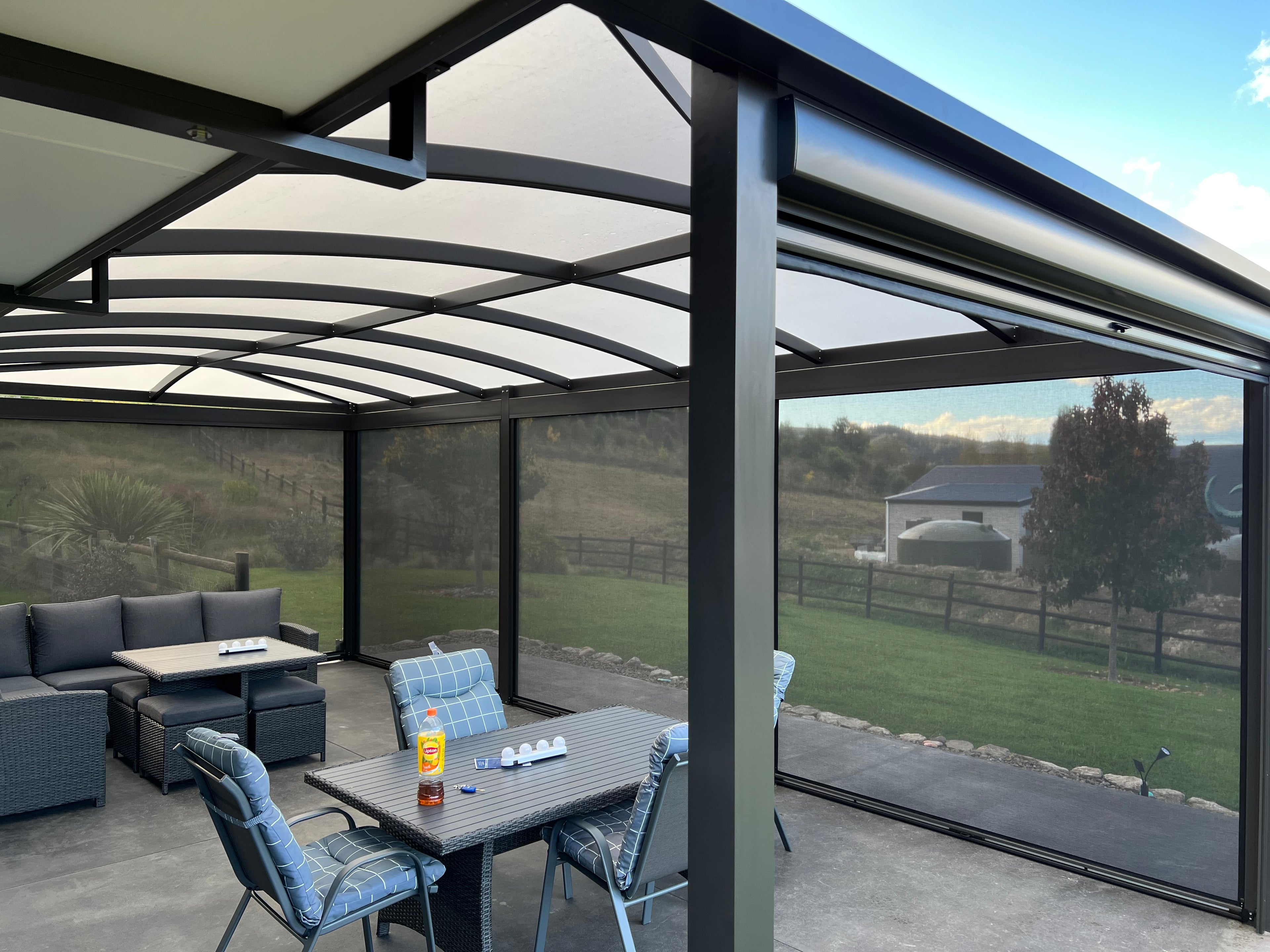 Outdoor patio area with a pergola, table, and chairs on a clear day.